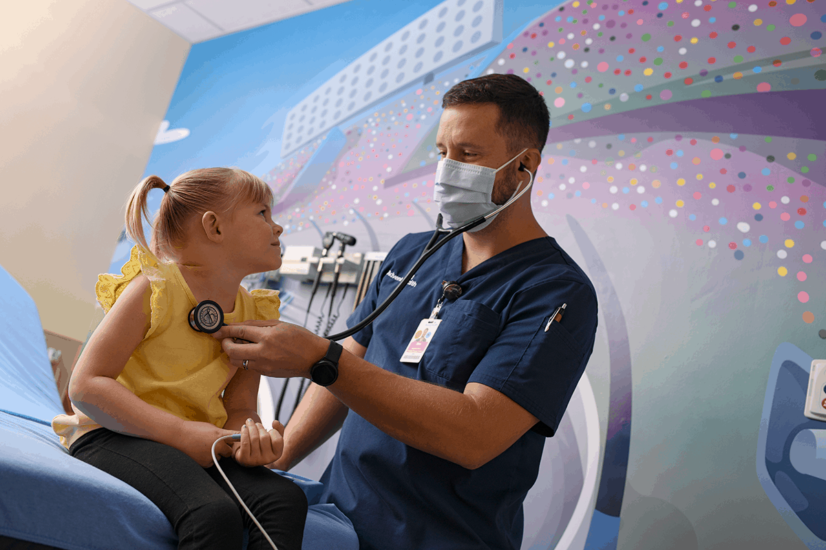 AdventHealth A healthcare worker performing a medical examination on a child using a stethoscope.